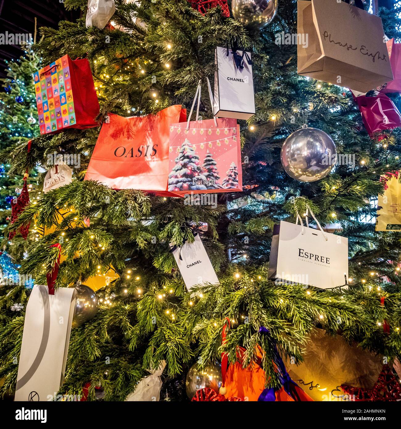 Borse per lo shopping con il designer i nomi di marca appeso su albero di Natale. Foto Stock