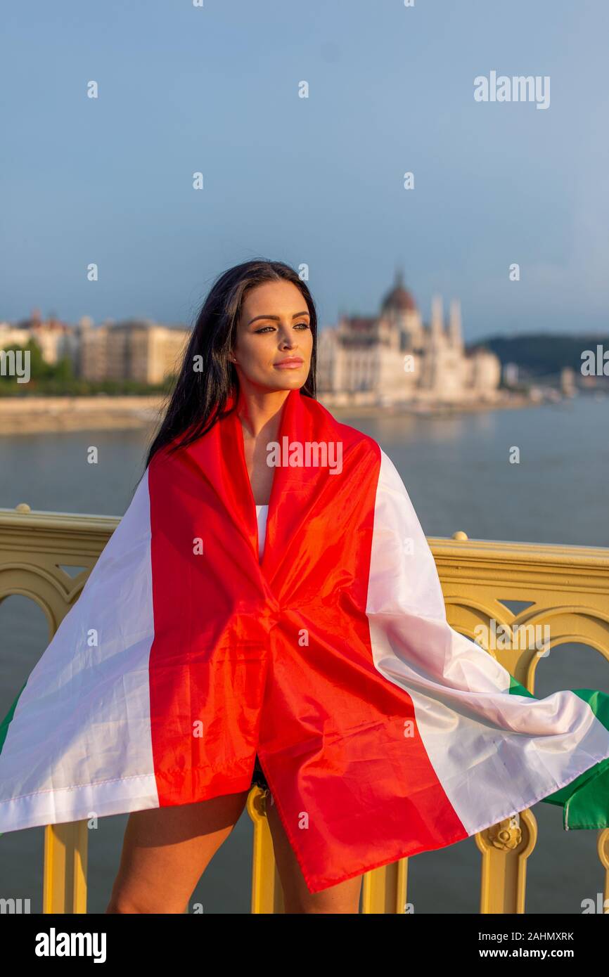 Giovane donna coperta dalla bandiera ungherese che pongono a Budapest, Ungheria Foto Stock