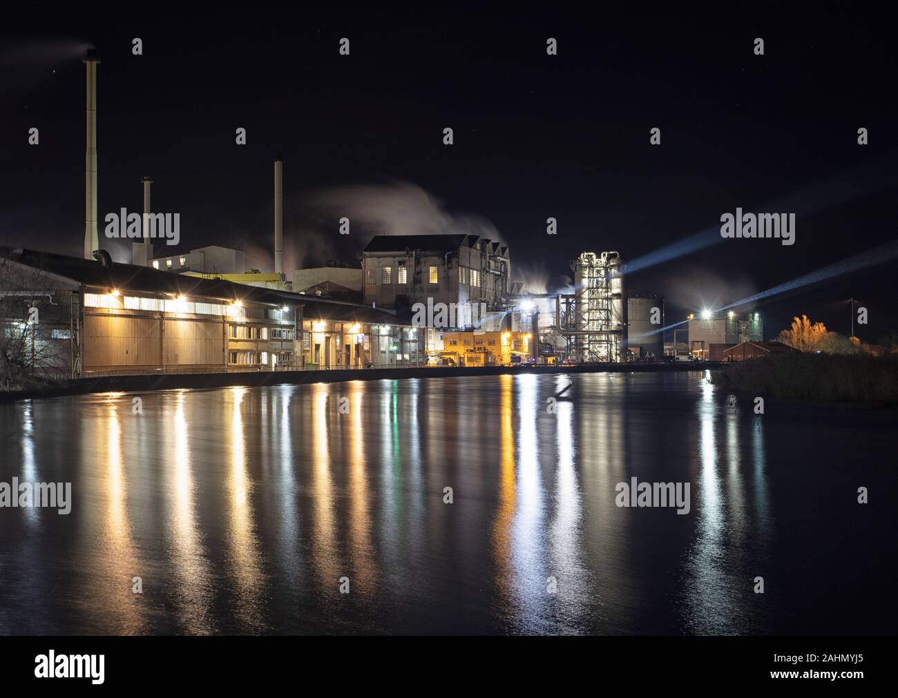 Cantley barbabietola da zucchero di fabbrica attraverso il lavoro le ore scure, edifici riflessa nel fiume y vengono, Norfolk Foto Stock