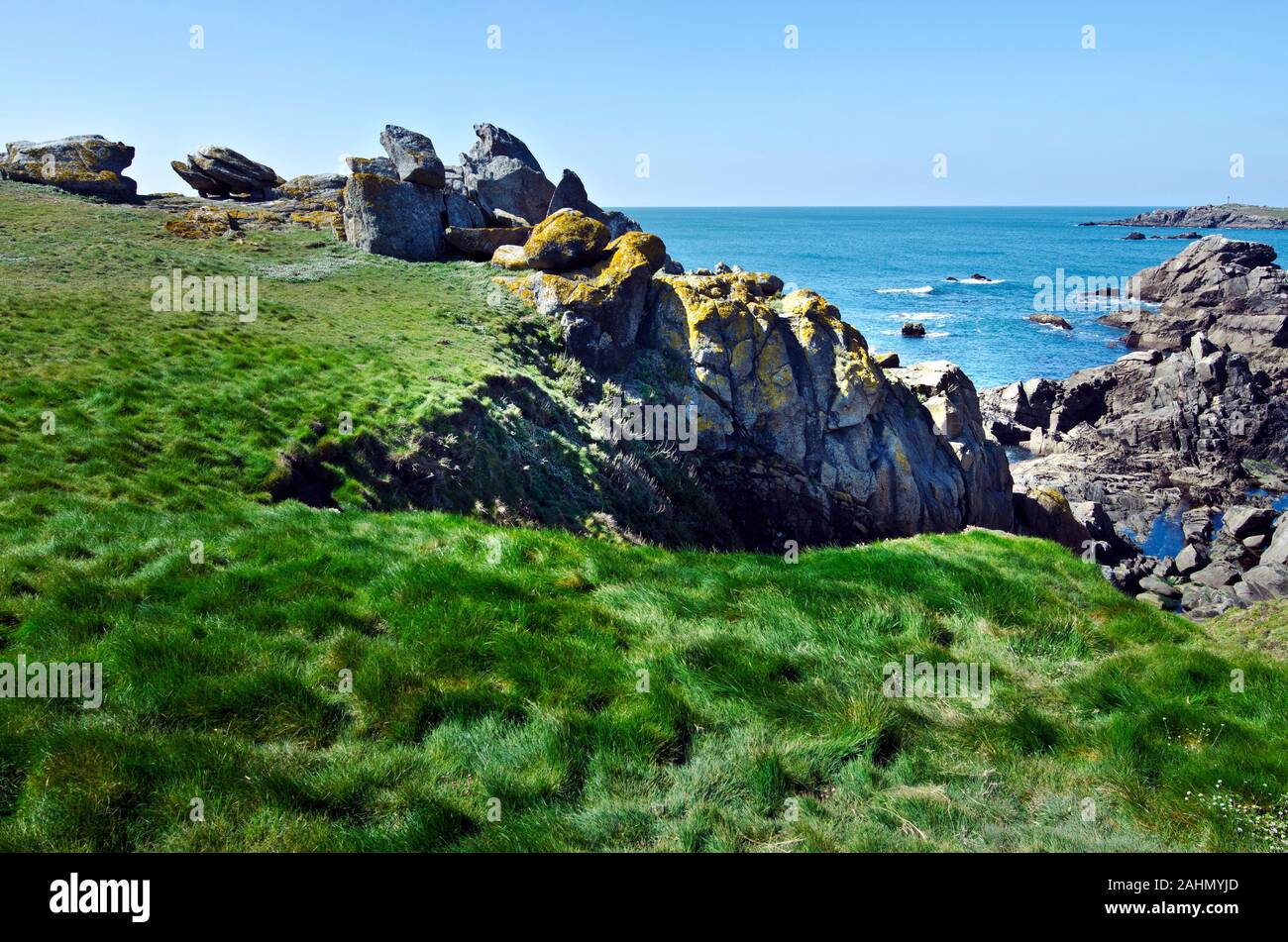 Panorama di selvaggia costa rocciosa nel sud-est dell'isola di Yeu con erba verde in primo piano. Francia, Vendee, Pay de la Loire Foto Stock