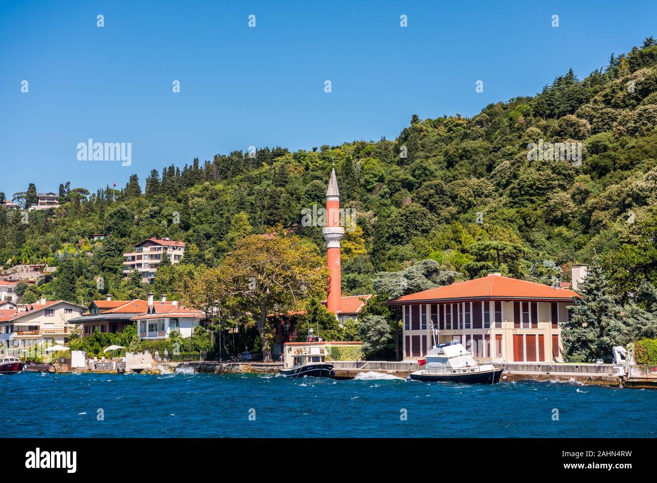 Bella moschea e mansions at la costline e hillslope con bagno turco bandiera nazionale e foresta verde d'estate, presso lo stretto del Bosforo a Istanbul,Tur Foto Stock