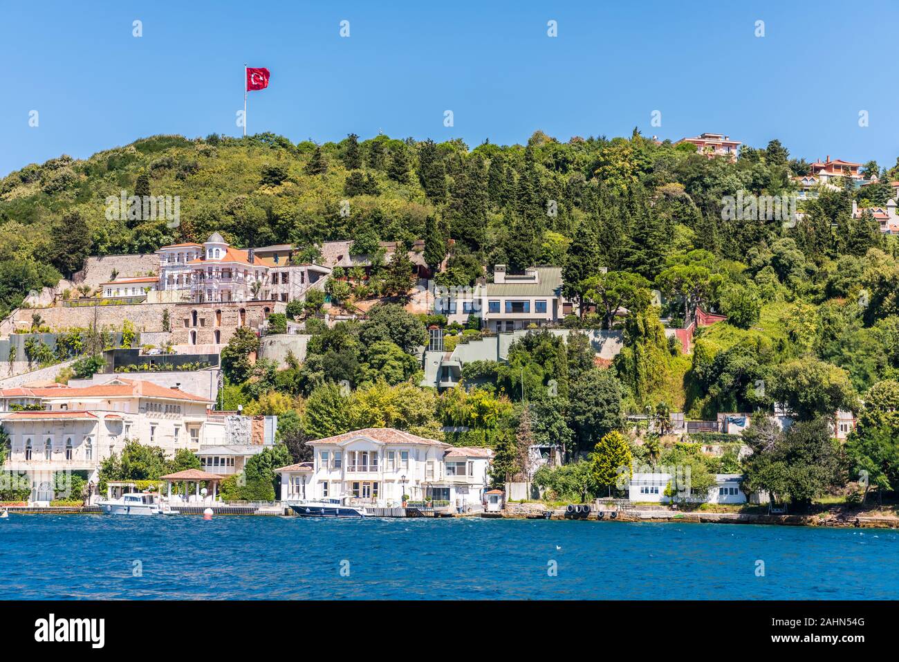 Bella builings e palazzi signorili alla costline e hillslope con bagno turco bandiera nazionale e foresta verde d'estate, presso lo stretto del Bosforo a Istanbul,T Foto Stock