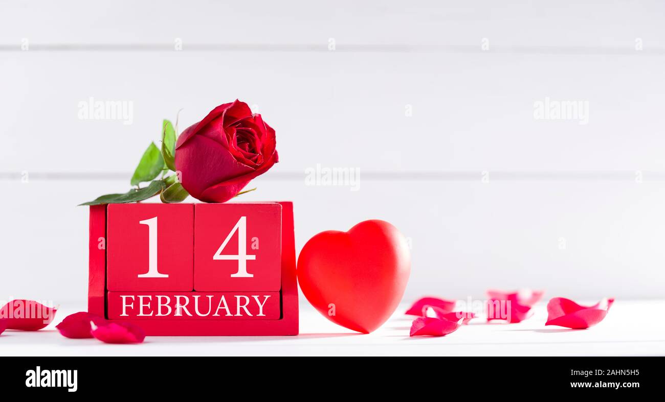 Il giorno di San Valentino del concetto. Febbraio 14 lettera sul calendario di legno e le rose sulla scrivania Foto Stock