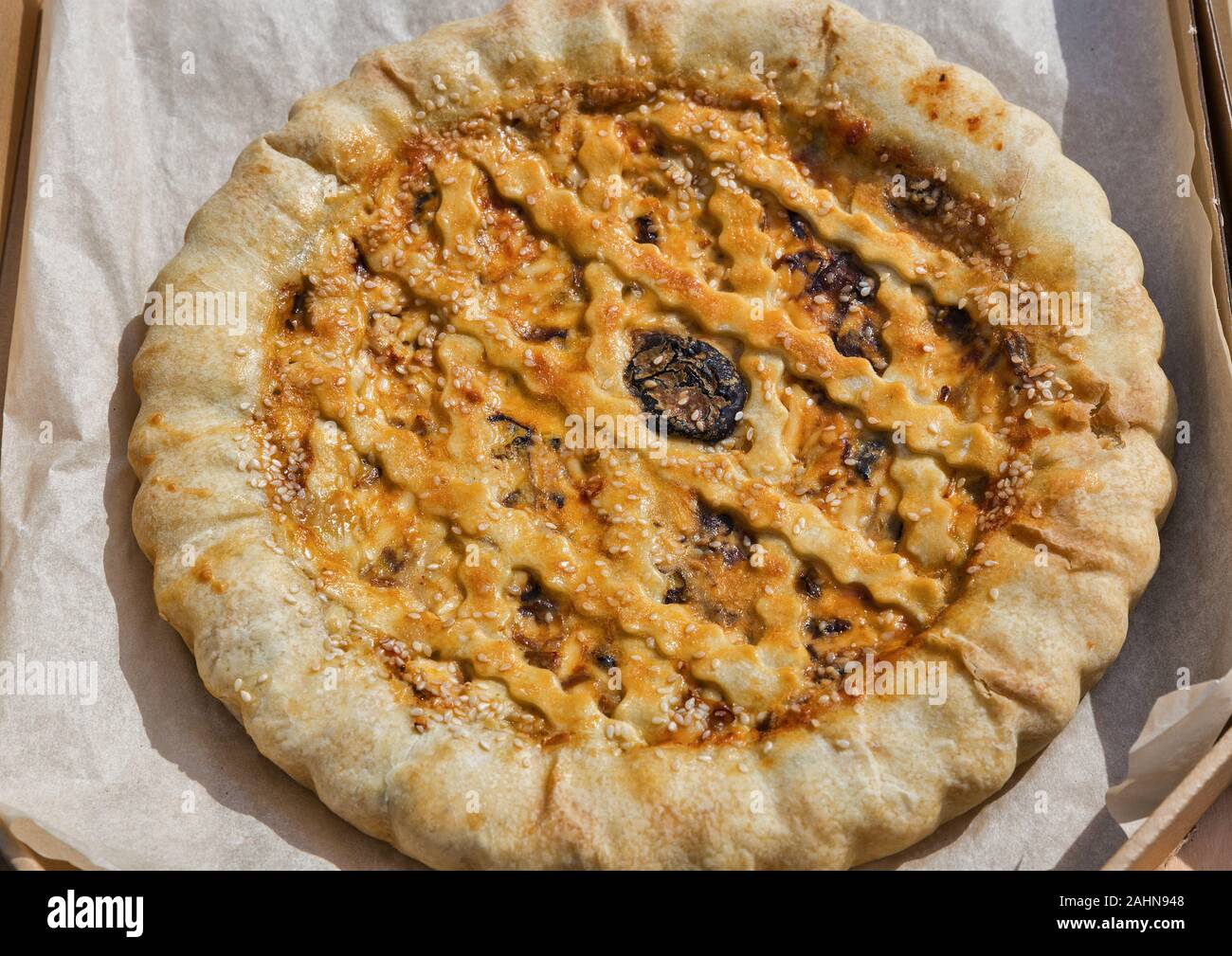 Gustosa torta salata con carne, i semi di sesamo e pomodori secchi closeup Foto Stock