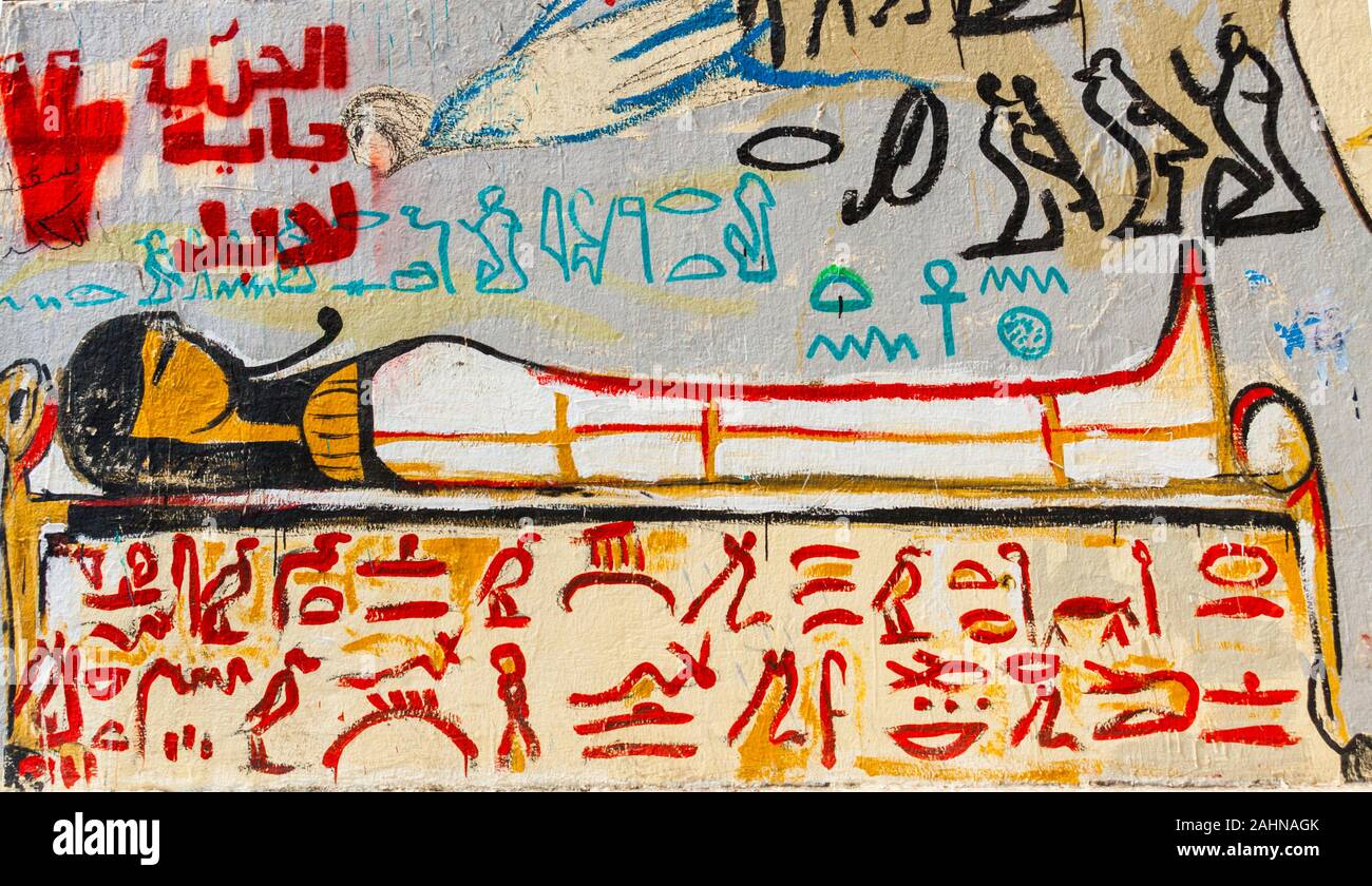 L'Egitto, al Cairo, graffiti della rivoluzione egiziana su Mohamed Mahmoud Street. Ispirato dalla antichità egizie, una mummia su un letto mortuario. Foto Stock