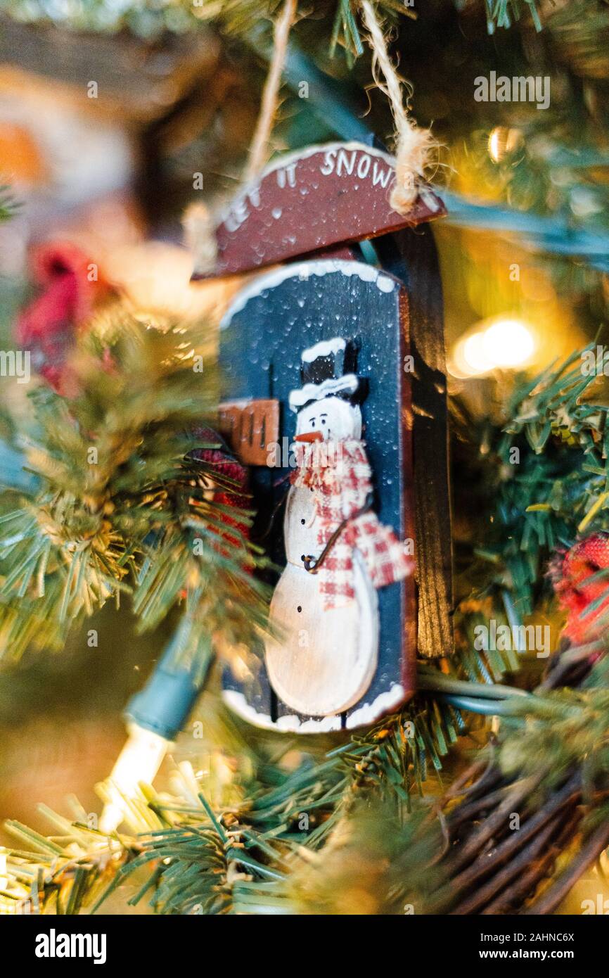 Vintage fatti a mano rustica lasciarlo neve pupazzo di ornamento su albero di Natale con luci Foto Stock