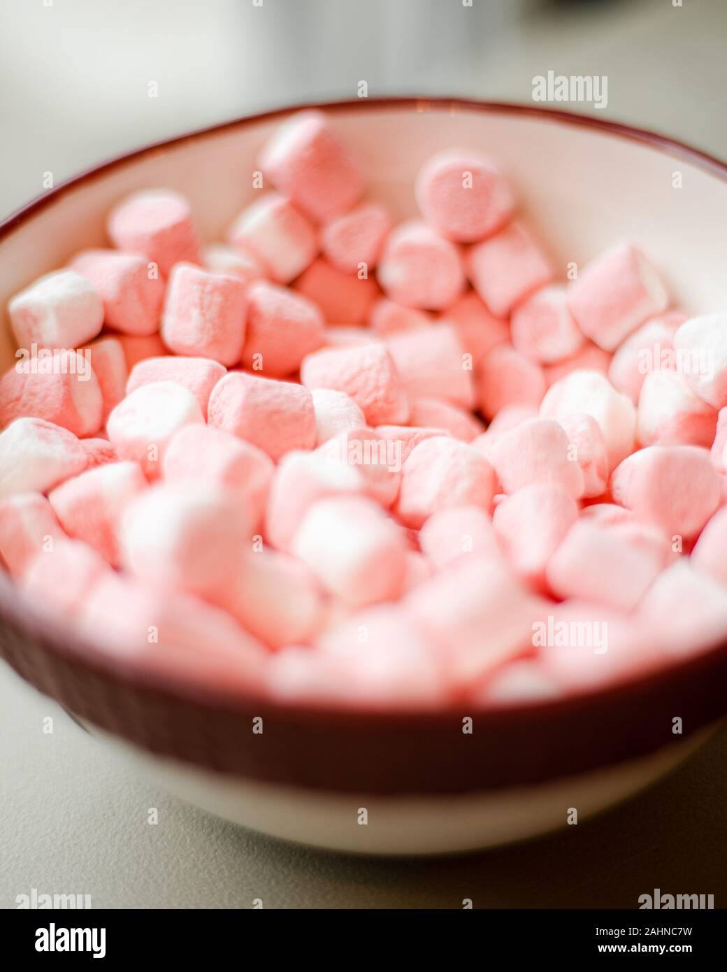 Piccola miniatura dolce gustoso zuccherino di colore rosa e bianco marshmallows in vacanza ciotola con sfondo sfocato Foto Stock