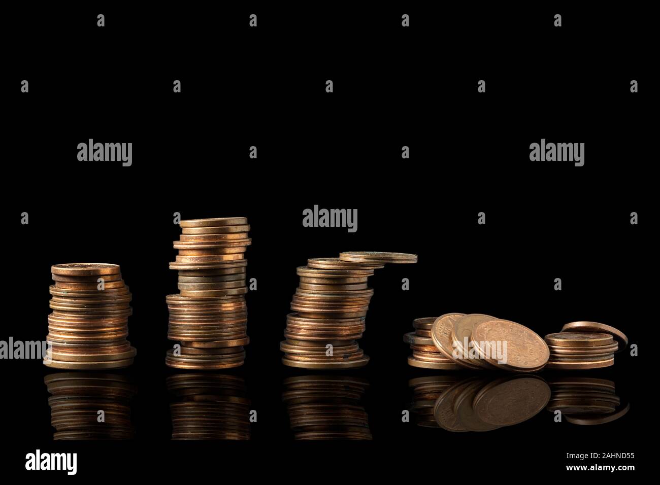Pile di monete riflessa isolata su uno sfondo nero con abbondanza di spazio di copia. Riflesso penny crollare le torri, il concetto di economia. Foto Stock