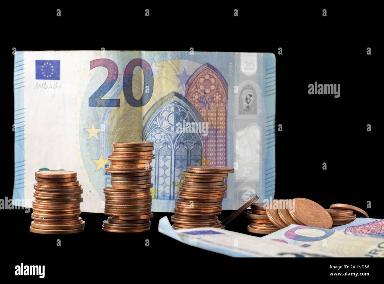 20 di banconote in euro e la moneta di pile isolate su uno sfondo nero. Foto Stock