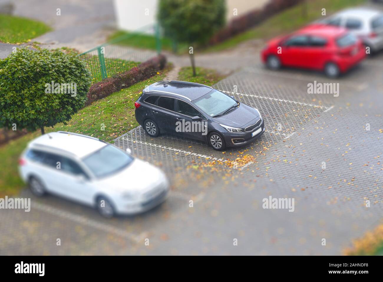 Piccolo parcheggio con diverse auto visto da sopra con tilt shift effetto Foto Stock