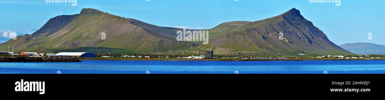 Vista panoramica a Akrafjall mountain e Akranes cittadina al confine della Baia di Faxa nella regione di Vesturland dell Islanda. Vista da Sudurflos reef. Foto Stock