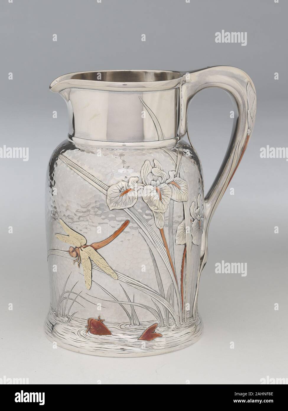 Tiffany e società. Brocca. 1878. La città di New York. Argento, oro e rame asimmetrica la scena dell'acqua, realizzata attraverso una combinazione di martellamento, incisione e applicati elementi metallici, avvolge il corpo del lanciatore. La vignetta è stata quasi certamente ispirato il lavoro di Katsushika Hokusai, artista giapponese noto per la sua dinamica woodblock stampe del mondo naturale. Tiffany e della società biblioteca di progettazione incluse tre volumi di Hokusai di lavoro, molti utilizzante lo stesso grazioso iridi, animata di libellule, e spruzzi carp visibile su questo bricco. Foto Stock