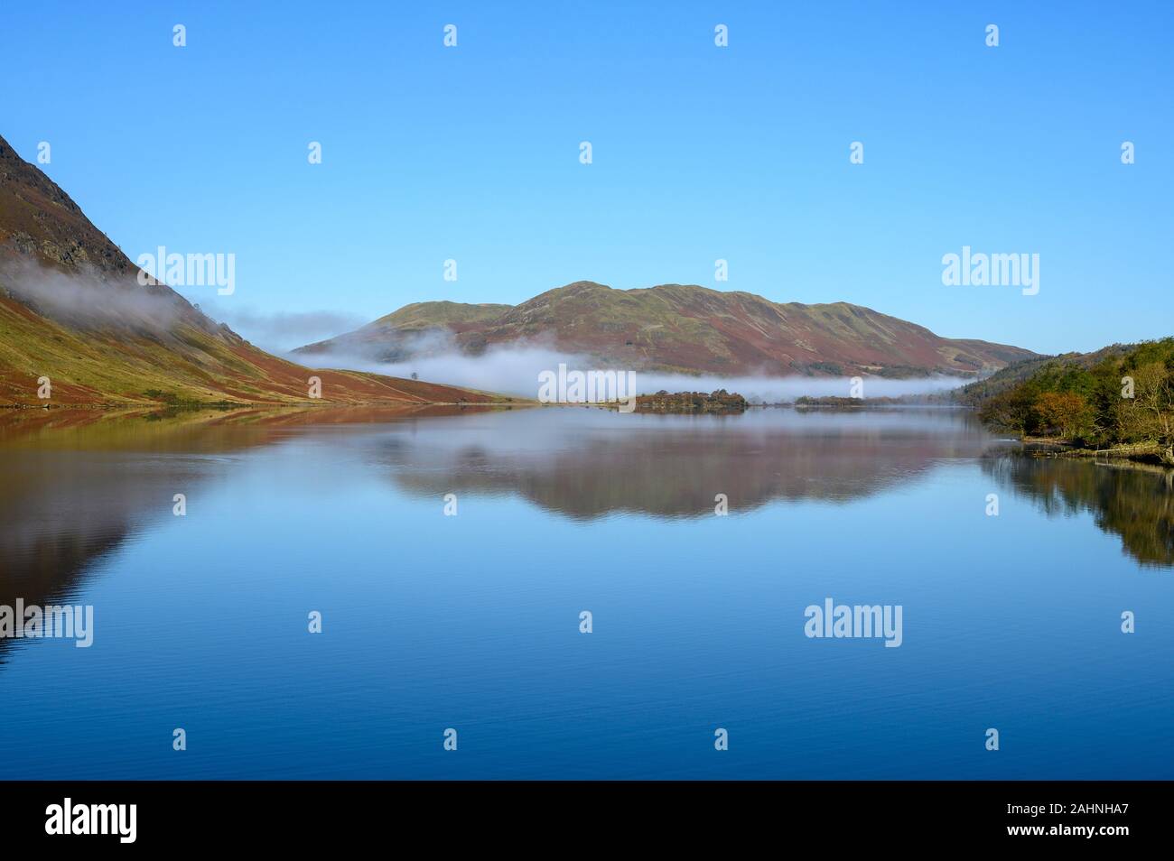 Vista su tutta Crummock acqua nel distretto del lago guardando verso il basso è sceso. Un banco di nebbia si trova in corrispondenza della parte superiore del lago Foto Stock