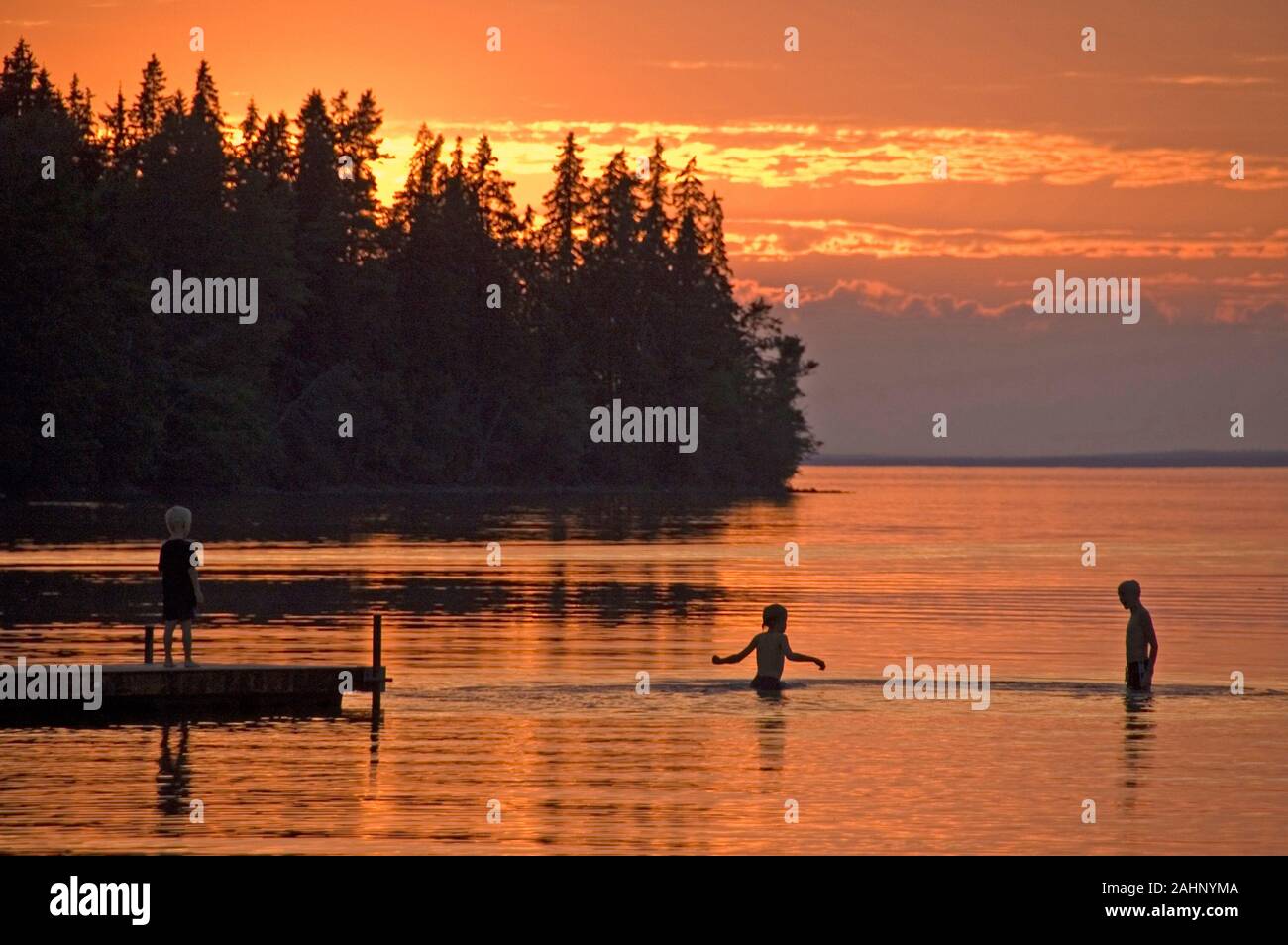 Skandinavien, Schweden, badende Kinder im Sonnenuntergang am See, Vätternsee bei Jernvid, Vaetternsee Foto Stock