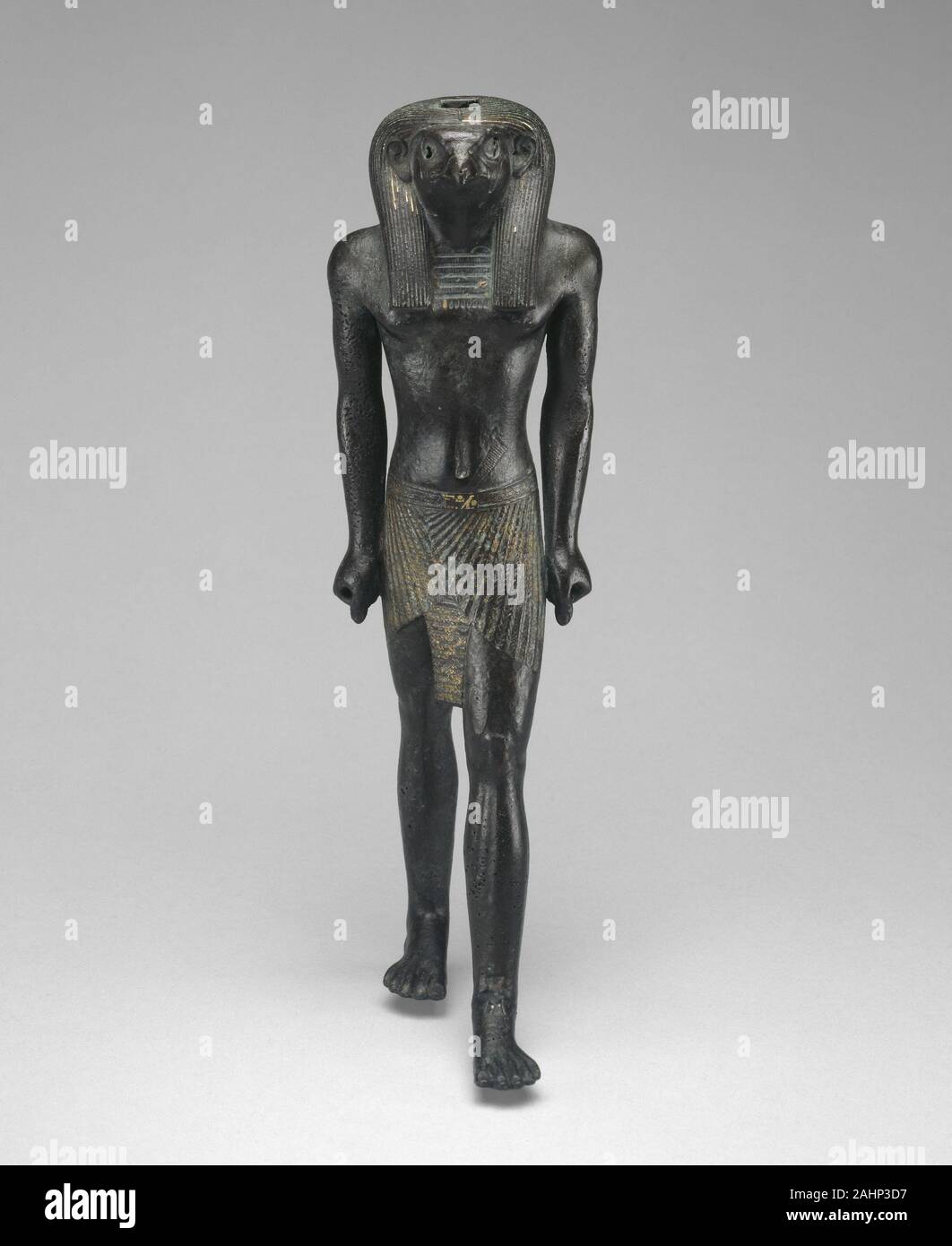 Antica egiziana. Statuetta di Re-Horakhty. 1069 BC-664 BC. L'Egitto. In lega di rame con doratura divinità egiziane erano comunemente rappresentato con corpi umani e teste di animali. Qui il dio Re-Horakhty, una combinazione della divinità solare ri e Horus, è identificato dal falco alla testa. La statuetta del corpo forte e atteggiamento dinamico esemplifica l'Egiziano artista della nozione ideale della figura maschile ed esprime il vigore e la potenza della Re-Horakhty, al quale la statuetta sarebbe stato dato come un'offerta. Foto Stock