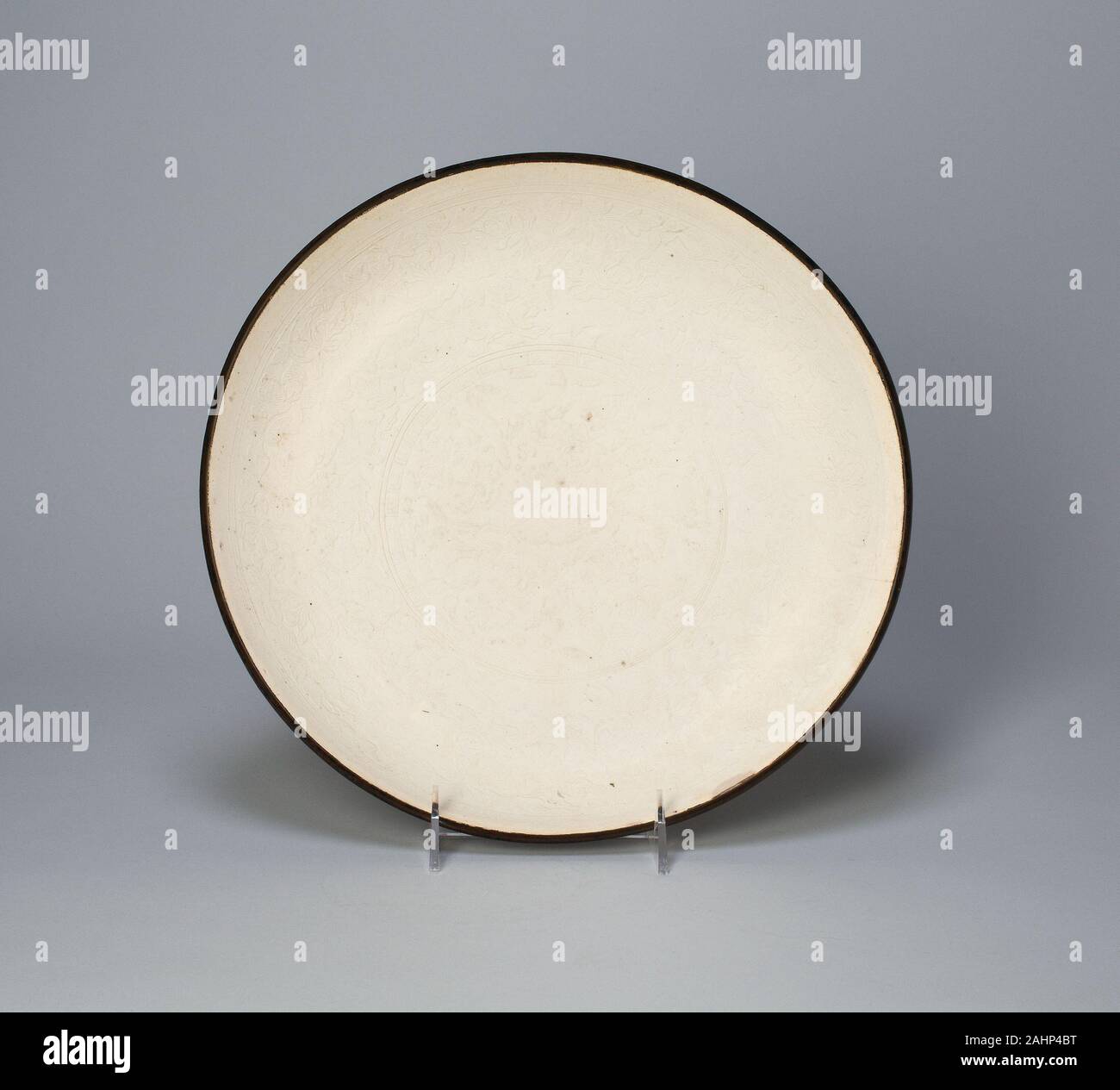 Piatto con Lotus, peonie e foglie stilizzate. 960 AD-1279. Cina. Ding ware; porcellana con stampo underglaze-decorazione impressa; rame rim Foto Stock