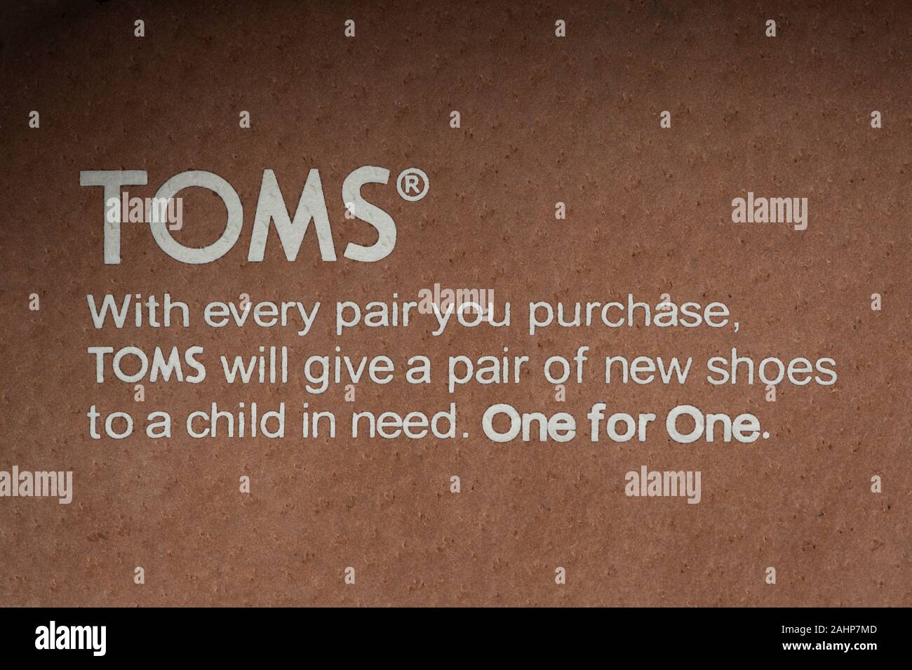 Un messaggio è visibile sulla soletta di un Toms Calzature Calzature prodotto accompagnato dalla frase "uno per uno". Foto Stock