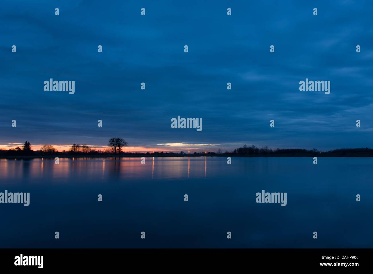 Nuvole scure dopo il tramonto sopra il lago Foto Stock