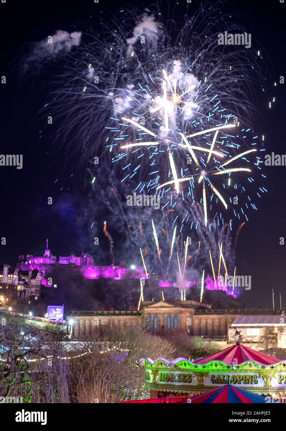 Fuochi d'artificio sono lasciate fuori dal Castello di Edimburgo durante l'Hogmanay festeggiamenti di Capodanno a Edimburgo. Foto Stock