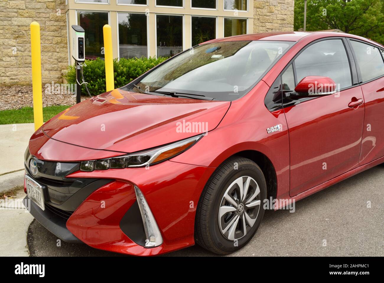 Auto elettrica ibrida plug-in, una Toyota Prius prime 2017 rossa di Barcellona, che si ricarica nella comunità Door County di Baileys Harbor, Wisconsin, Stati Uniti Foto Stock
