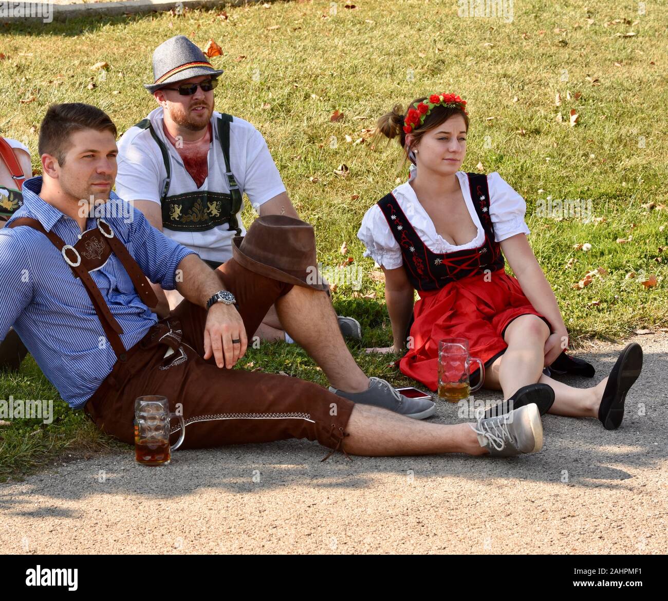 Giovani donne e uomini attraenti che partecipano al New Glarus Oktoberfest in tradizionale lederhosen o dirndl vestito, riposo, New Glarus, Wisconsin, USA. Foto Stock