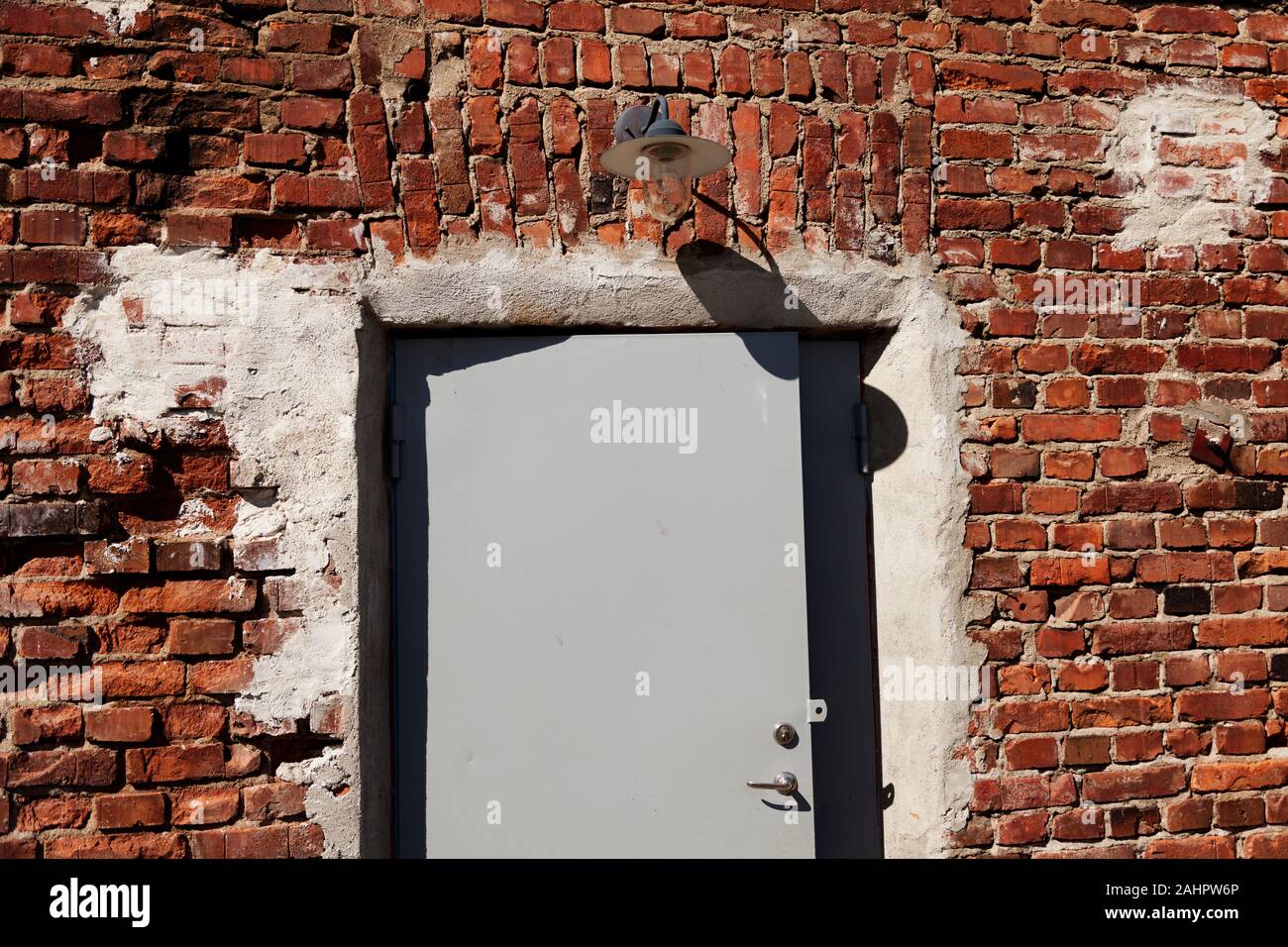 Un vecchio edificio in mattoni rossi con la nuova piastra porta e illuminazione Foto Stock