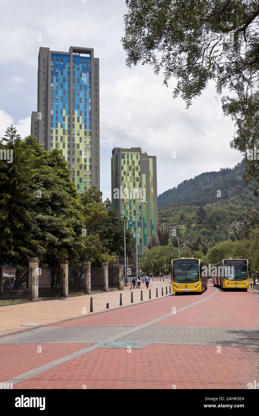 TransMilenio locale (BRT) autobus passano colorate torri residenziali sulla Avenida Jimenez in Candelaria distretto di Bogotà, Colombia Foto Stock