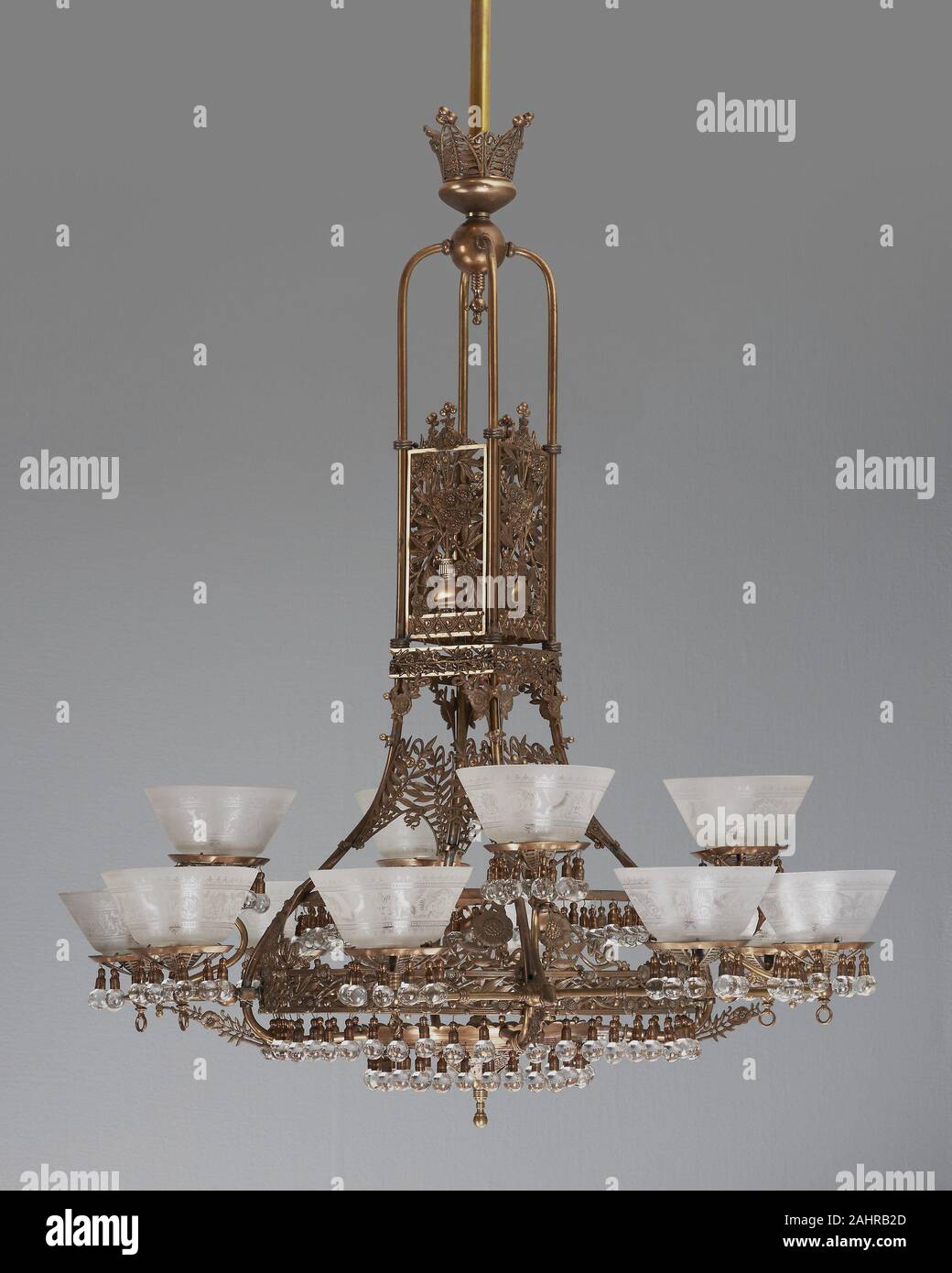 Thackara, Buck & Co.. Gasolier. 1880. Philadelphia. Ottone e vetro Questo gasolier è un apparecchio di illuminazione denominato per il suo originale fonte di luce, gas, che aveva un tremolio influenzano che sarebbero state amplificate dalle centinaia di ciondoli in vetro e le dodici vetro acidato sfumature apposta per il complesso telaio di ottone. Lamiera decorativa fiorì alla fine del XIX secolo con il sorgere di estetismo, un movimento culturale che apprezzate la bellezza in ogni aspetto della vita, compreso uno di arredi. Qui spray appiattita di fiori stilizzati e rami e foglie formano gli elementi strutturali dei gasoli Foto Stock