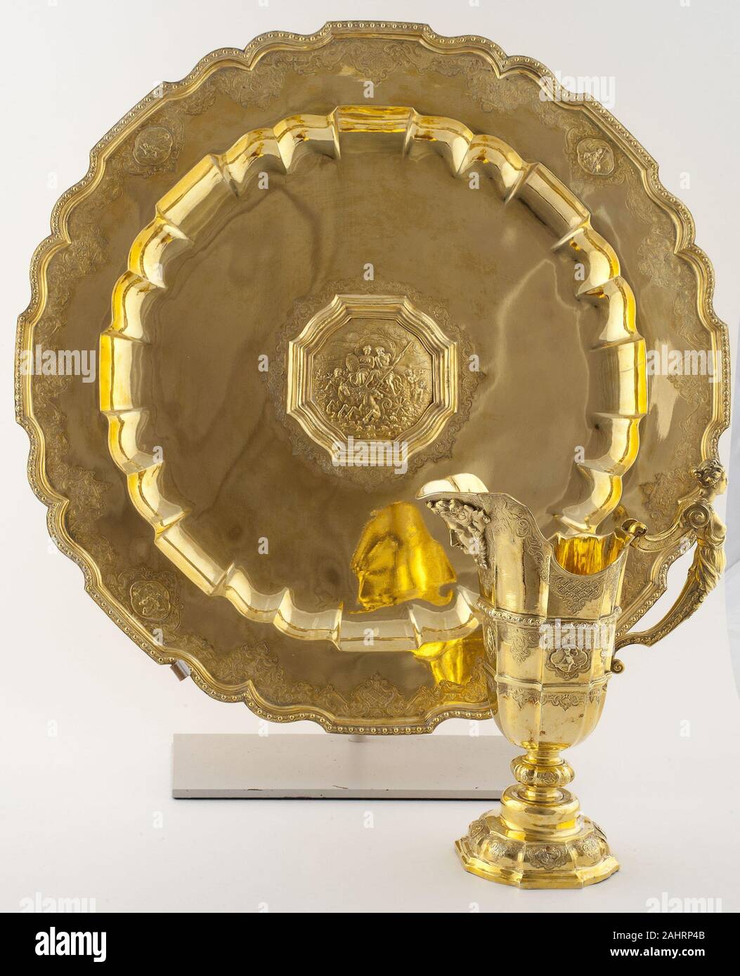 Johann Erhard Heuglin, II. Ewer e bacino. 1715-1725. Augsburg. Argento dorato a ewer e bacino era una necessità per la pulizia di se stessi nel XVII e XVIII secolo le abitazioni e la scelta dei materiali è stata un importante indicatore di una famiglia è stato. Peltro e ottone andavano bene per coloro che non potevano permettersi nulla grander, ma in argento dorato, di cui questo ewer e bacino sono realizzati, rappresentato il massimo del lusso aristocratico. Quando non è in uso, tali insiemi sono state mantenute nella piastra sala, dove una famiglia più splendida lamiera è stata visualizzata. In periodi di difficoltà finanziarie, argento le navi che sono state sistematicamente Foto Stock