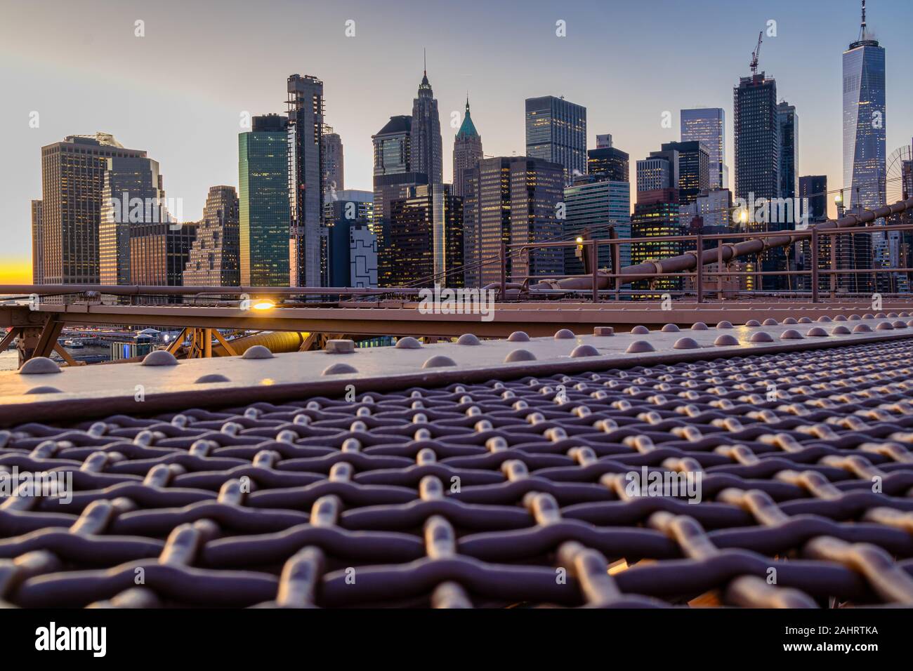 Skyline di New York dal ponte di Brooklyn al tramonto Foto Stock