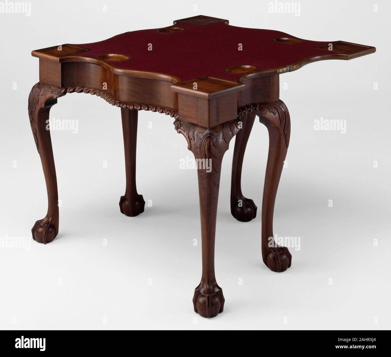 Artista sconosciuto. Tabella della scheda. 1755-1790. New York. Mogano con tulip, pioppo quercia bianca e pino bianco quando non è in uso, questa scheda tabella era destinato ad essere appoggiato contro una parete. Quando è necessario un terzo "swing" gamba sul retro della tavola è stato posto in corrispondenza di un angolo perpendicolare al supporto la parte superiore aperta. Aperta la tabella rivela quattro inset angoli squadrati dove candelabri che sono state poste. Il ovali incassate terrà la riproduzione di pezzi noti come i pesci che a causa della loro forma. I pezzi sono stati realizzati usualmente in madreperla o avorio, e sono stati mantenuti in un piccolo segreto cassetto nella parte posteriore della tavola. Foto Stock