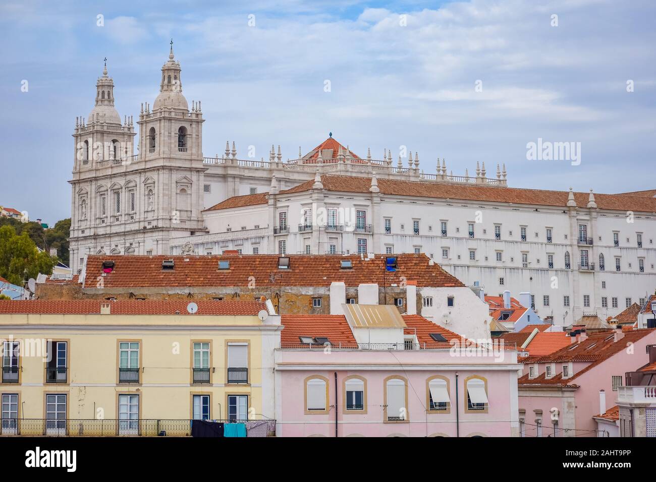 Le pareti colorate degli edifici di Lisbona, con tetti di colore arancione e la chiesa di Sao Vicente di consessi in background. Giornata di sole e cielo blu in estate Foto Stock
