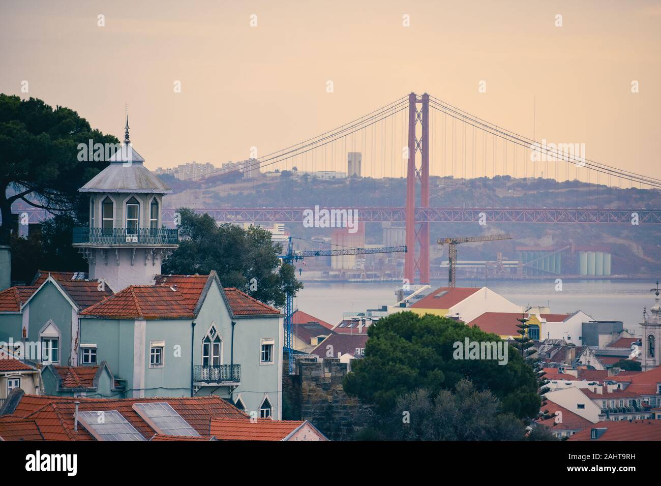 Lisbona vista panoramica. Le pareti colorate degli edifici di Lisbona, con tetti di colore arancione e il venticinquesimo del ponte di aprile in background, al tramonto. Viaggiare Foto Stock