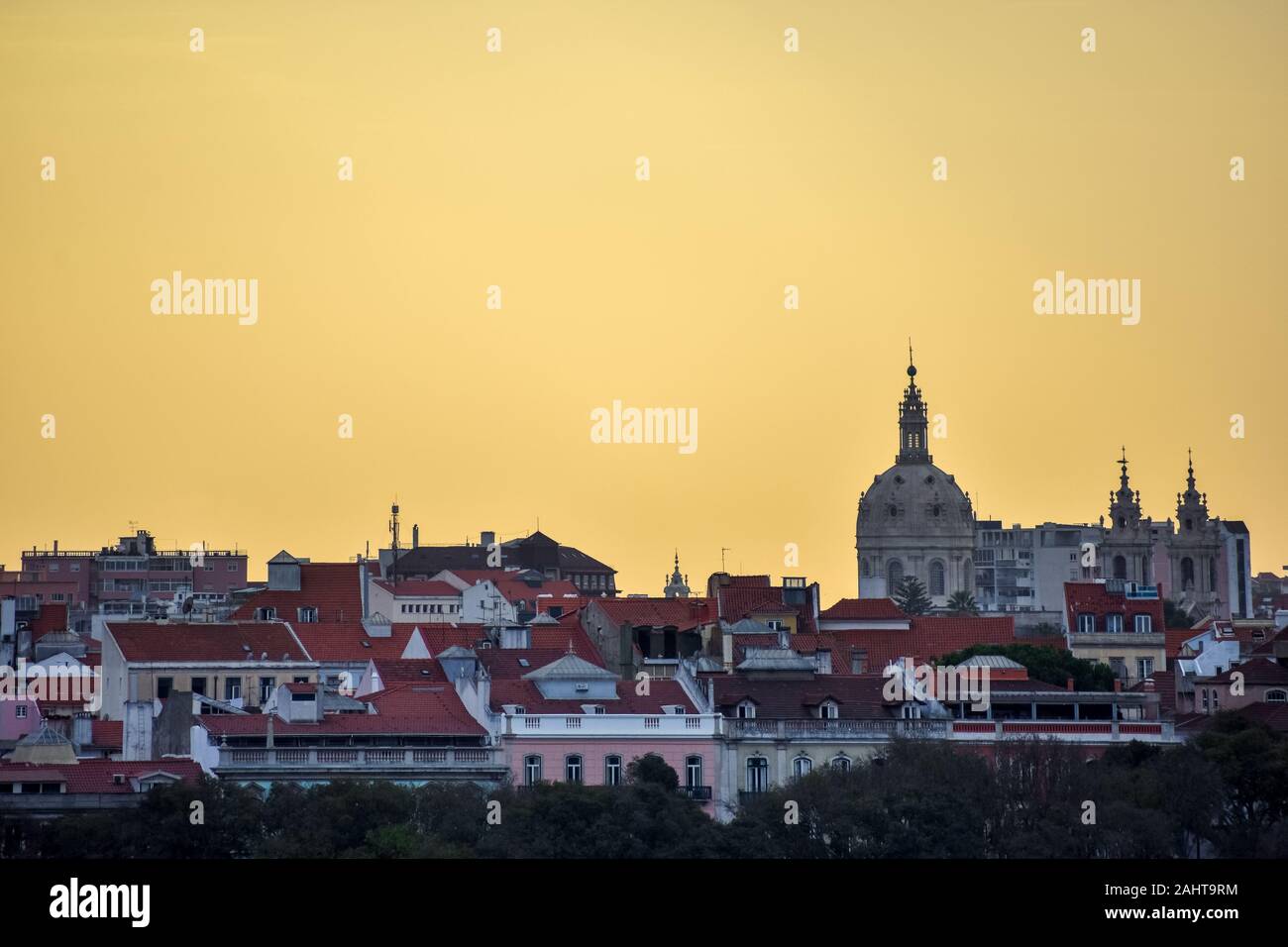 Lisbona vista sullo skyline. Le pareti colorate degli edifici di Lisbona, con tetti di colore arancione e la Basílica da Estrela al tramonto. Viaggi e real estate concep Foto Stock