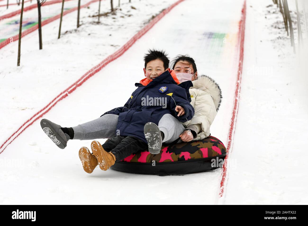 (200101) -- LIANYUNGANG, 1 gennaio, 2020 (Xinhua) -- Le persone godono di tubi di ghiaccio in corrispondenza di una stazione sciistica in Lianyungang, est cinese della provincia di Jiangsu, 1 gennaio, 2020. Le persone in tutta la Cina ha aderito varie attività sportive nel giorno di Capodanno. (Foto di Si Wei/Xinhua) Foto Stock