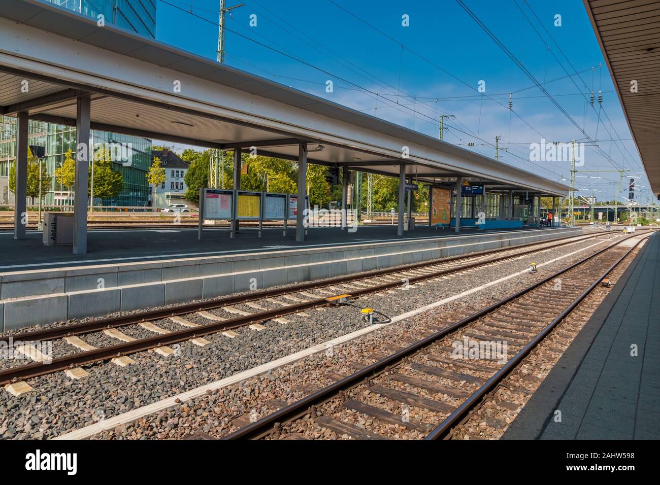 Ottima vista di una piattaforma vuota della stazione ferroviaria principale di Mannheim, Germania su una bella giornata con cielo blu. Foto Stock