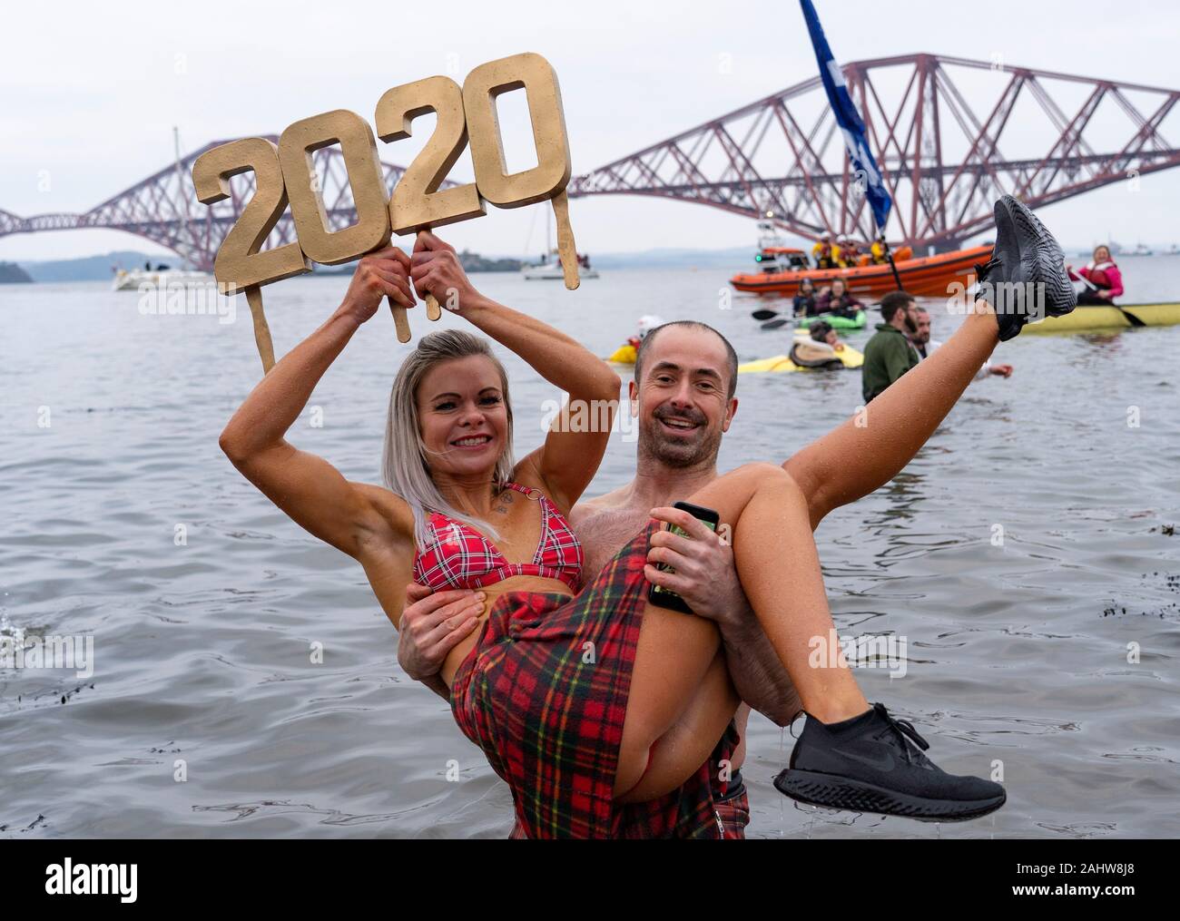 South Queensferry, Scotland, Regno Unito. Il 1° gennaio 2020. La gente in costume prendere il tuffo nel Firth of Forth river durante l annuale il giorno di Capodanno Loony Dook a South Queensferry. Iain Masterton/Alamy Live News Foto Stock