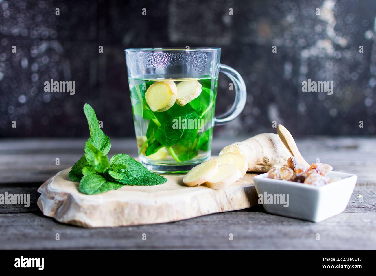 Il tè con la menta fresca e lo zenzero pezzi su una tavola di legno. Ideale come di un eye-catcher. Foto Stock