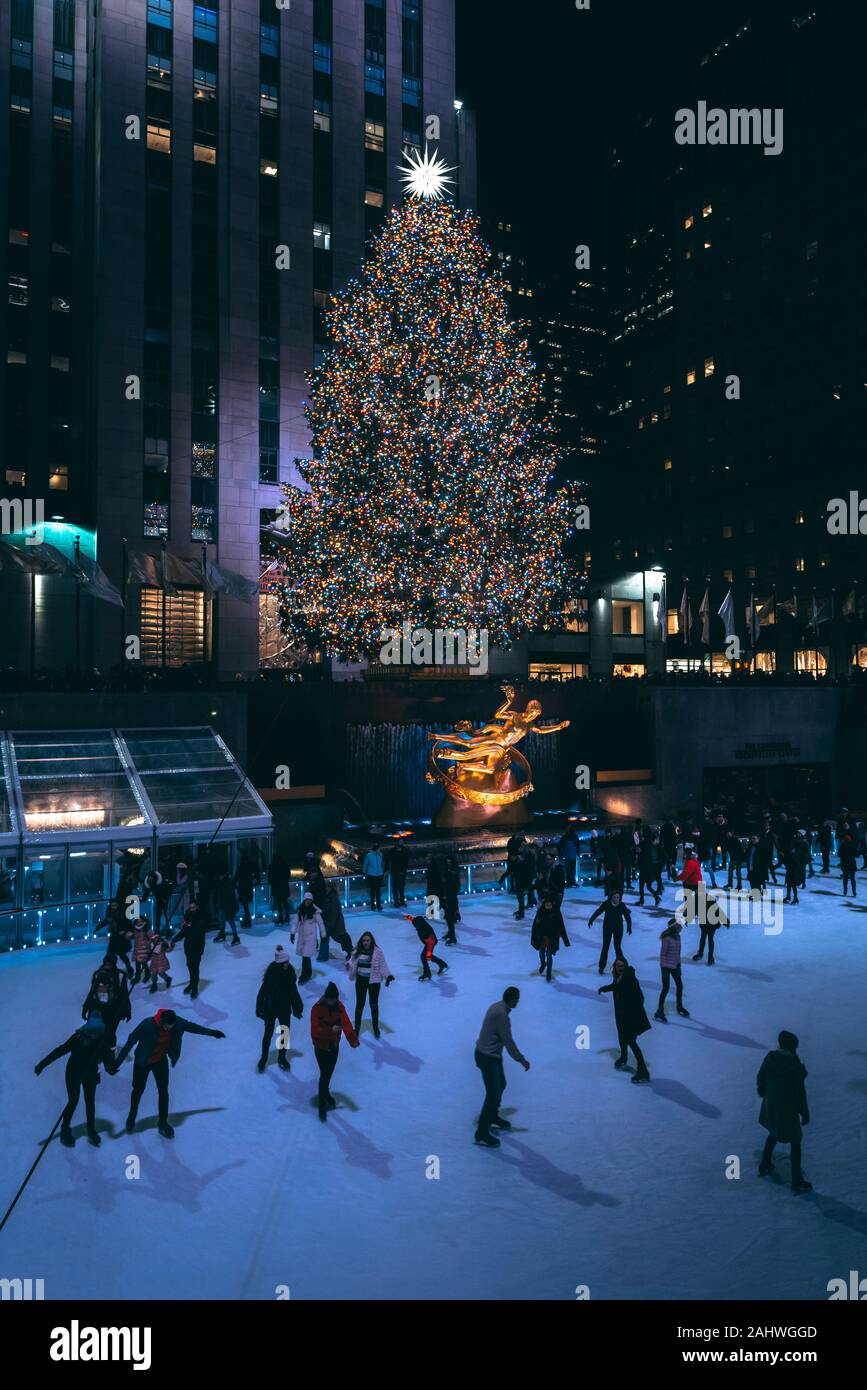 Albero di natale e la pista di pattinaggio su ghiaccio al Rockefeller Center di notte in Midtown Manhattan, a New York City Foto Stock