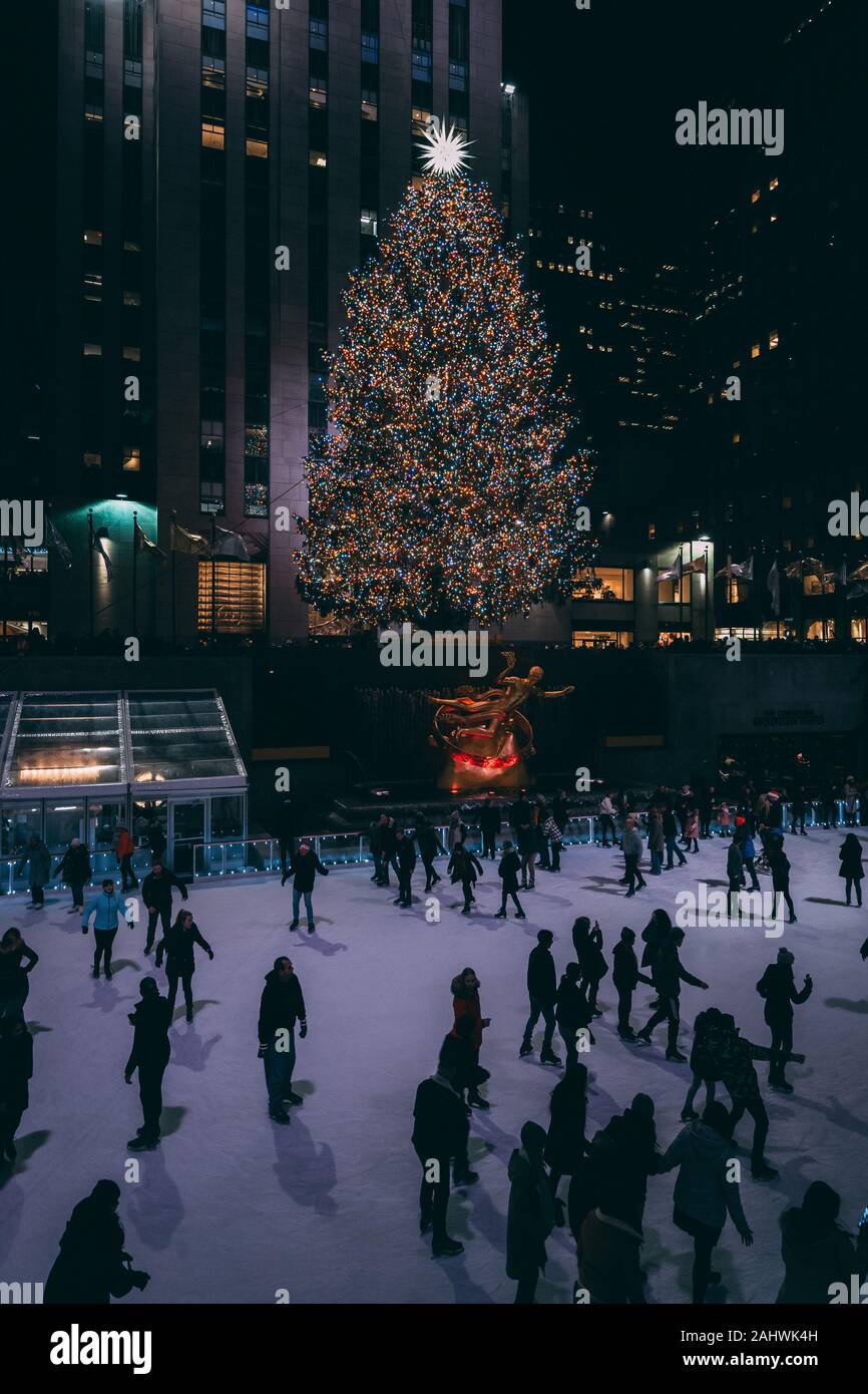 Albero di natale e la pista di pattinaggio su ghiaccio al Rockefeller Center di notte in Midtown Manhattan, a New York City Foto Stock