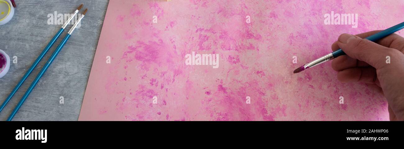 Vista superiore della donna dipinto a mano sfondo rosa, artistico occupazione creativa Foto Stock