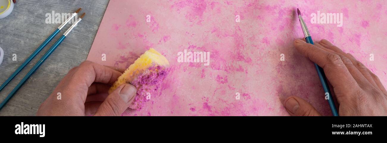 Vista superiore della donna dipinto a mano sfondo rosa, artistico occupazione creativa Foto Stock
