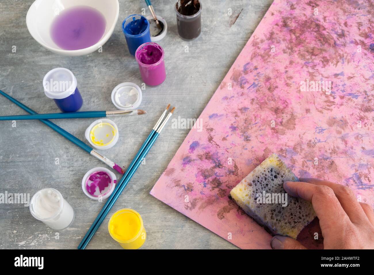 Vista superiore della donna dipinto a mano sfondo rosa, artistico occupazione creativa Foto Stock