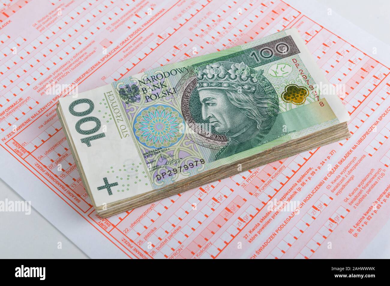 Pila di zloty polacco banconote sulla sommità di una sicurezza sociale forma Foto Stock