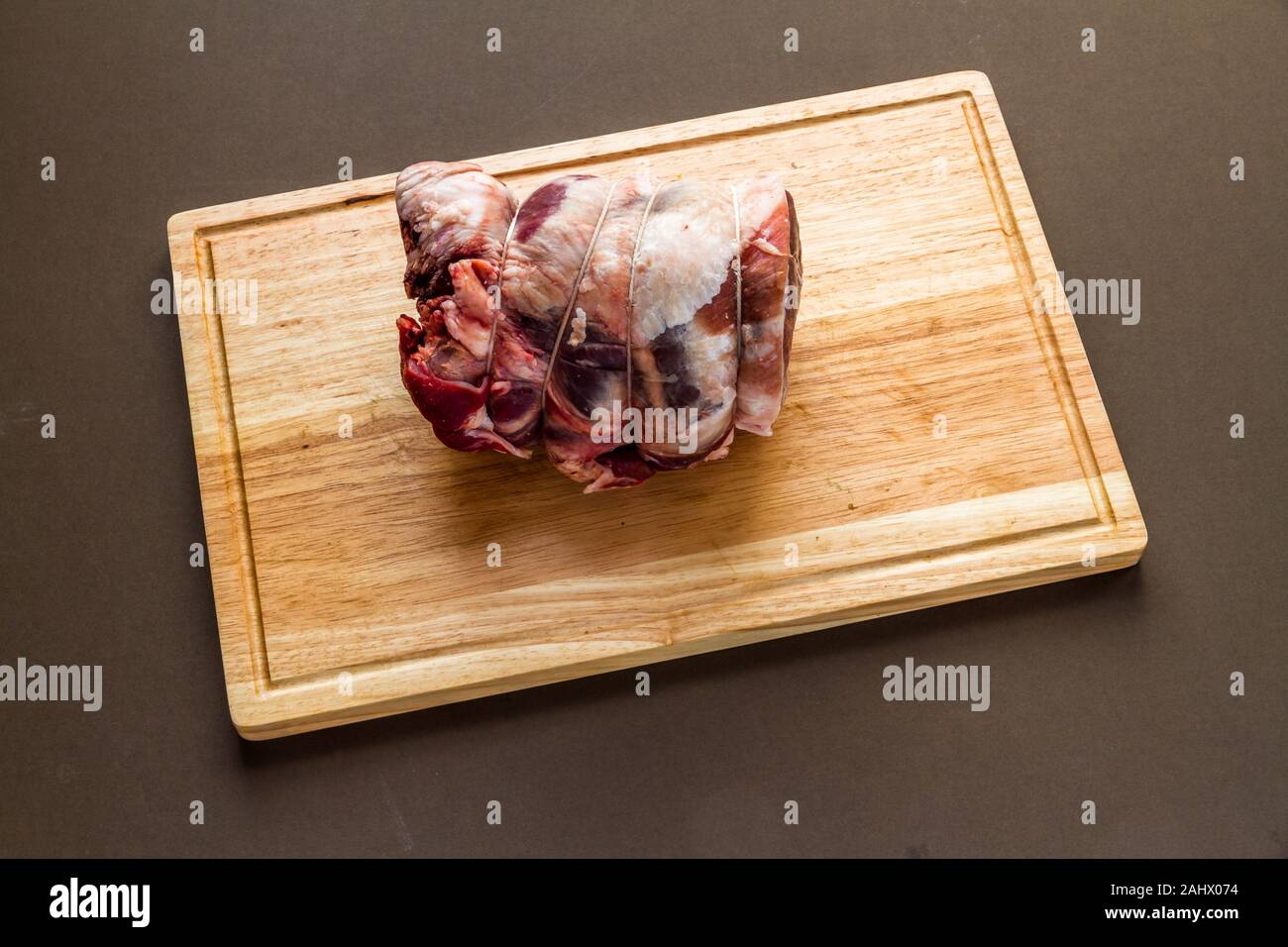 Lake District UK Herdwick crudo di pecora agnello laminato congiunta con i macellai string su legno tagliere. Foto Stock