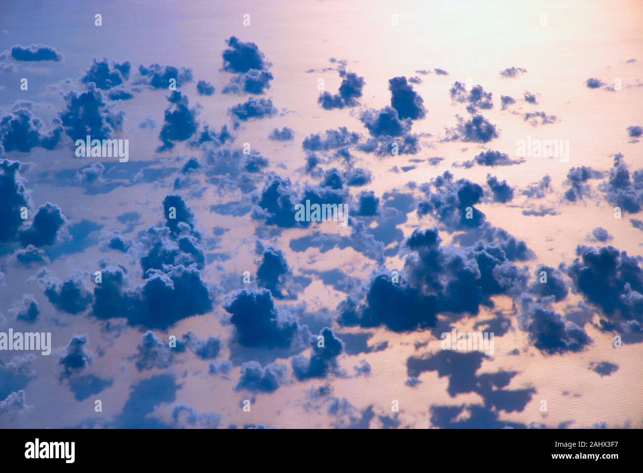 Bella vista da finestra di aereo sopra le nuvole e la superficie del mare. Panorama naturale con le nuvole. Nuvole bianche si muove al di sopra della superficie dell'acqua di mare. Foto Stock