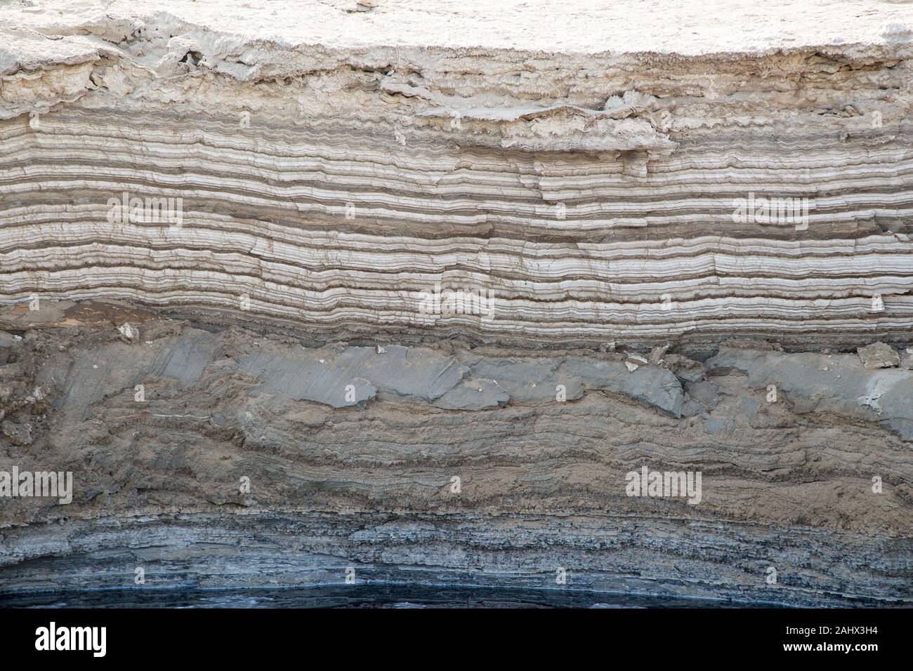 Strati annuali di sale e minerali depositati sulla riva del Mar Morto in Israele e esposti dal calo dei livelli dell'acqua. Foto Stock