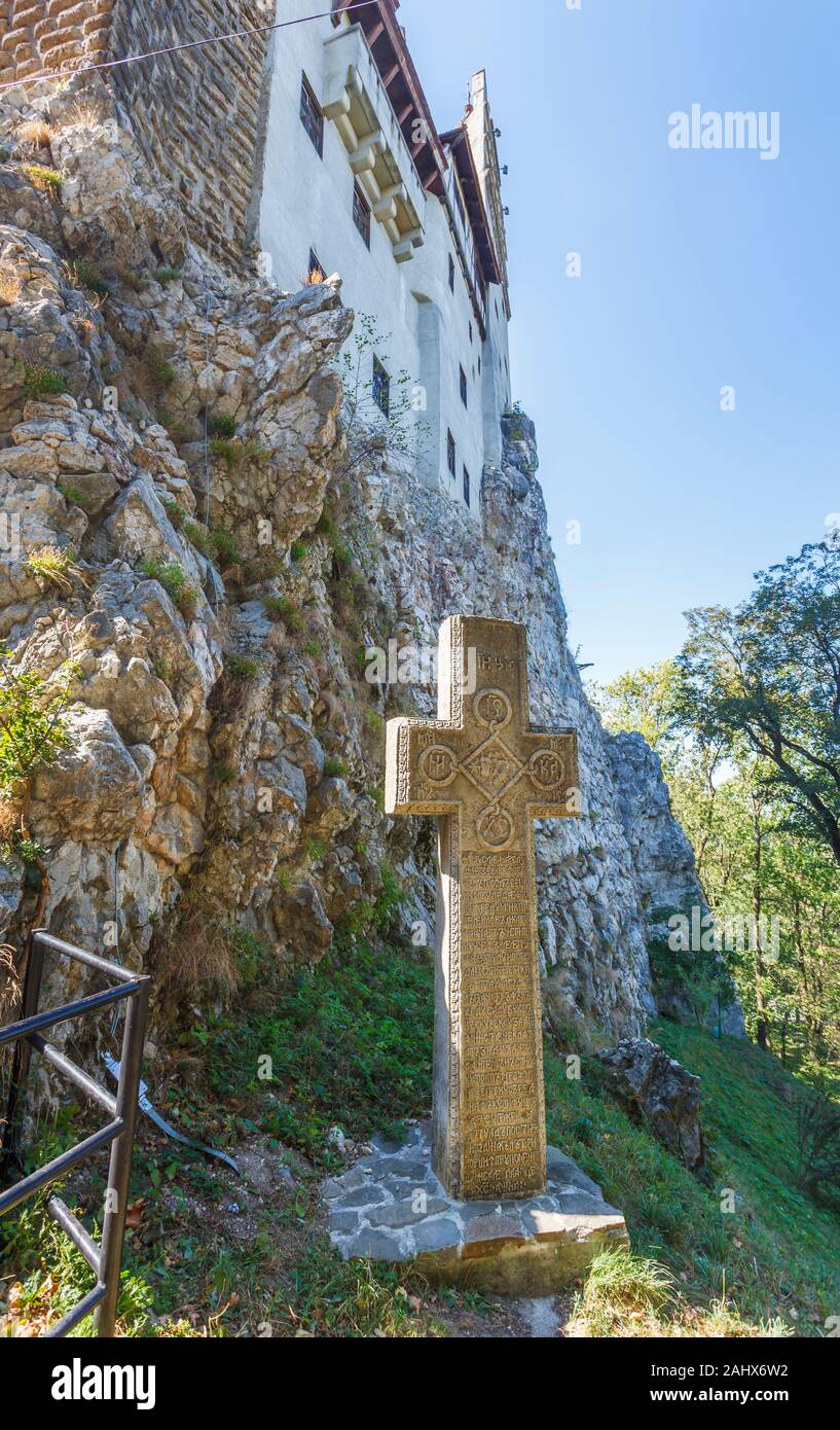 Croce di pietra ai piedi del medievale est della parete di scudo, Castello di Bran, casa del leggendario vampiro Conte Dracula, crusca, Transilvania, Romania Foto Stock