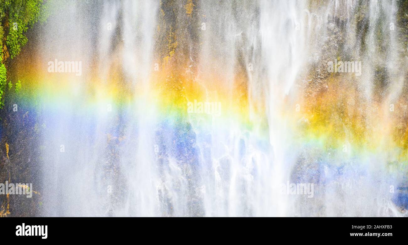 Vista ravvicinata della Tumpak Sewu cascate noto anche come Coban Sewu con un bellissimo arcobaleno formata dalla rifrazione della luce in goccioline d'acqua. Foto Stock