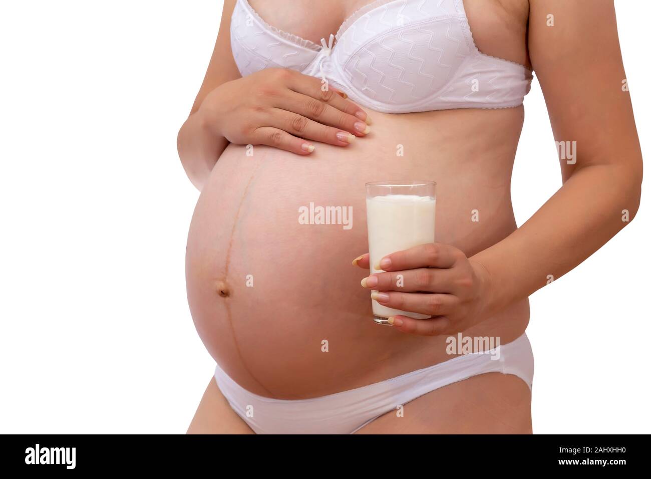 Donna incinta tenendo un bicchiere di latte al suo pancino. Concetto Pregnan: sana nutrizione durante la gravidanza. Foto Stock